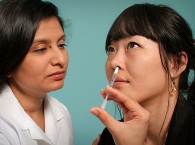 woman holding syringe near woman wearing black top
