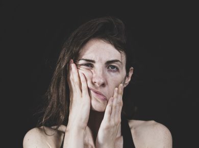 A woman in the stress making wired face by hands