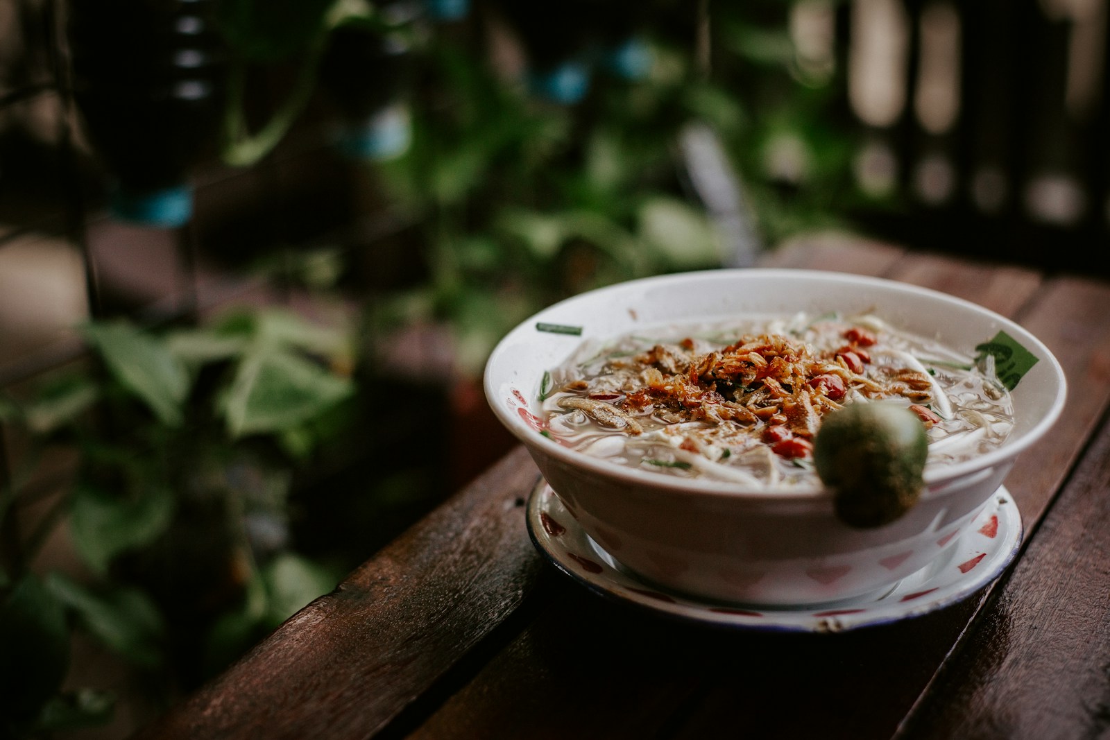 bowl of steaming soup sits on a rustic wooden table, inviting and warm